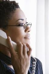 a photo of a woman listening intently to someone talking to her on the phone.